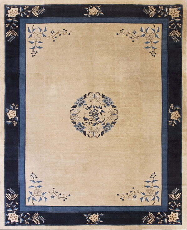 Light beige rug detailed with a central blue floral medallion and thick dark blue botanical borders.