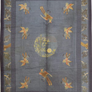 Blue patterned rug featuring stylized birds, a central bamboo motif, and a dark blue Greek key border.