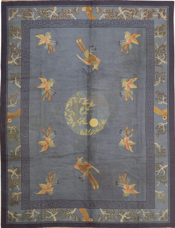 Blue patterned rug featuring stylized birds, a central bamboo motif, and a dark blue greek key border.