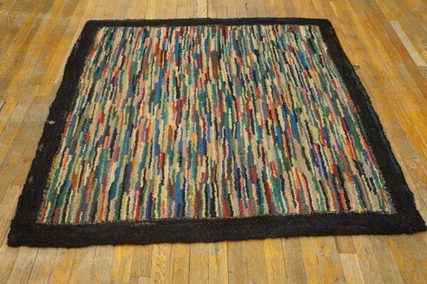 High pile, shaggy rug featuring colorful vertical stripes and a solid dark border on hardwood floors.