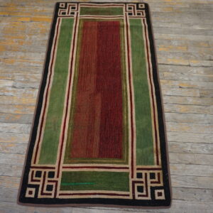 Geometric runner rug in red, green, black, and beige on weathered gray wood flooring.