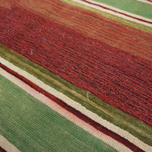 Diagonal striped rug featuring textured bands of dark red, light green, olive, and cream colors.
