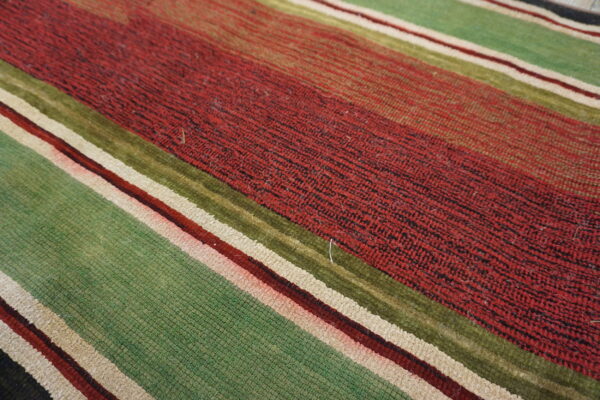 Diagonal striped rug featuring textured bands of dark red, light green, olive, and cream colors.
