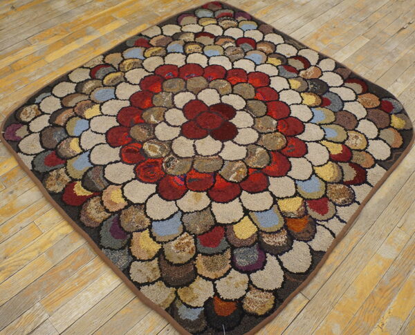 Multicolored scale-patterned high-pile rug featuring red and cream tones sits on distressed yellow wood planks.
