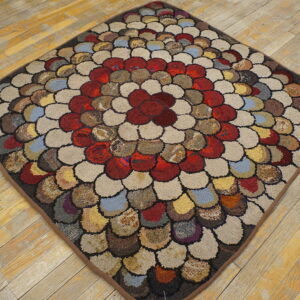Textured, diamond-shaped rug with a multicolored pebble pattern rests on rustic wood plank flooring.