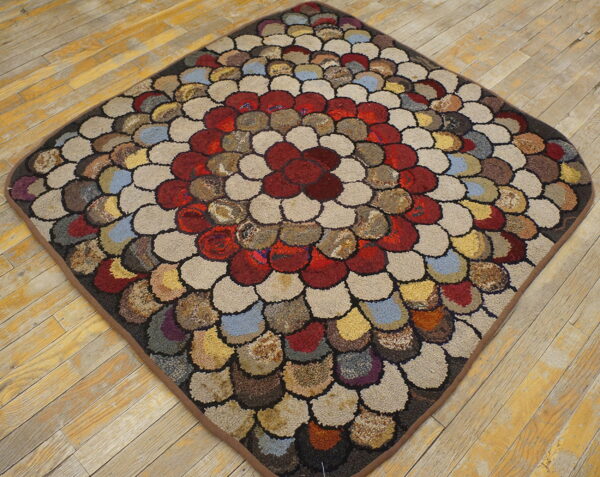 Textured, diamond-shaped rug with a multicolored pebble pattern rests on rustic wood plank flooring.