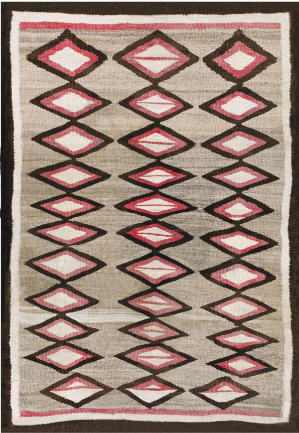 A gray flatwoven textile with vertical rows of dark brown, pink, and white layered diamond shapes.