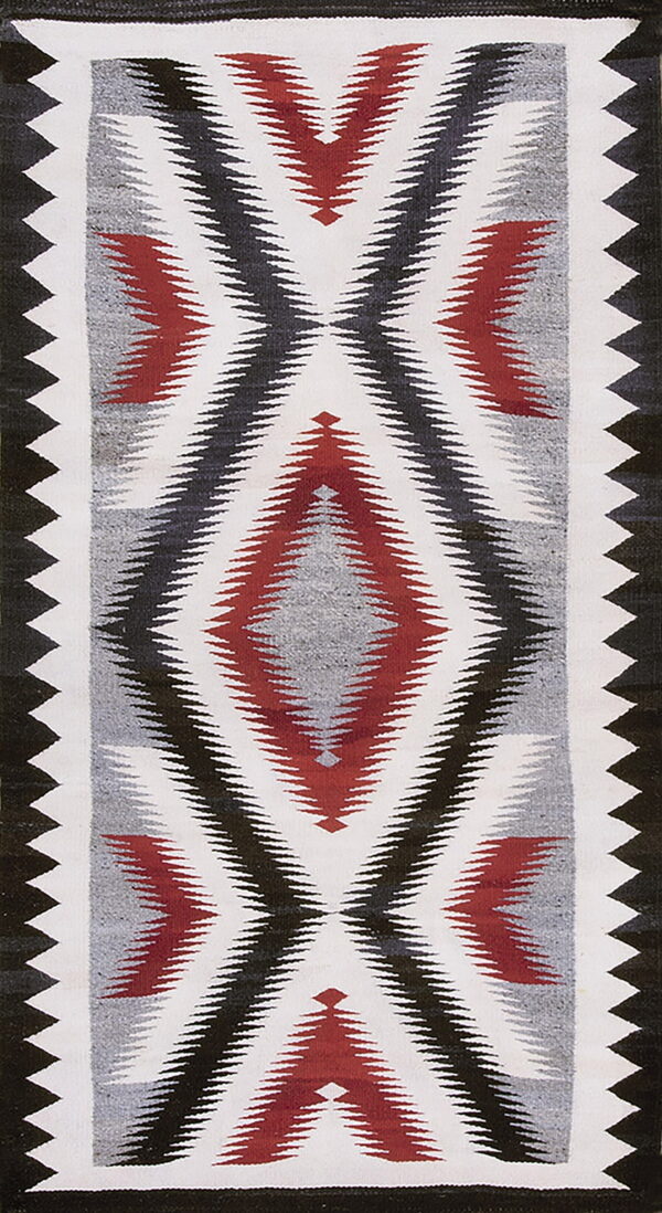 Geometric flatweave rug featuring serrated diamonds in red, black, gray, and white colors.
