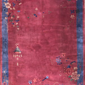 Berry red rug with a dusty blue border featuring colorful trailing florals and vines around an open field.