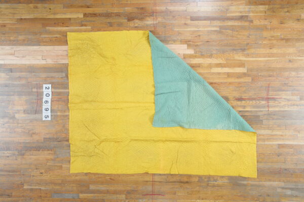 Quilt america antique knotted wool 1920s multicolor small scatter size rug 2 Yellow and aqua reversible quilted textile with stitched patterns displayed on natural wood flooring.