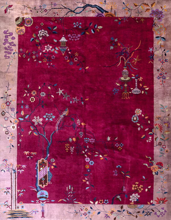 Berry red rug with a wide mauve border and a vibrant, detailed pattern of flowering branches and birds.