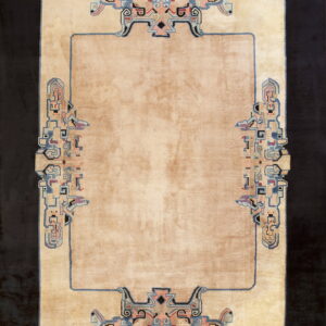 A beige high-pile rug features a plain center and complex stylized blue and pink Art Deco borders.