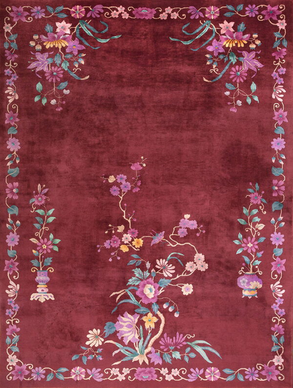 Plush maroon rug featuring elaborate pink, purple, and teal floral sprays and a continuous vine border.