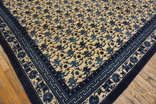Beige rug with a dense blue cloud pattern and complex geometric borders resting on hardwood floors.