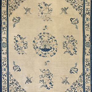 Light beige rug featuring a dark blue border and delicate blue floral and bird patterns across the field.