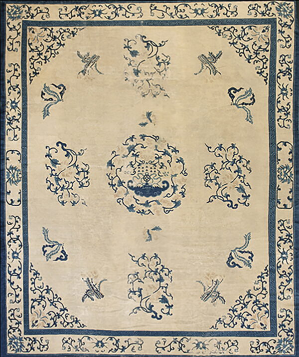 Light beige rug featuring a dark blue border and delicate blue floral and bird patterns across the field.