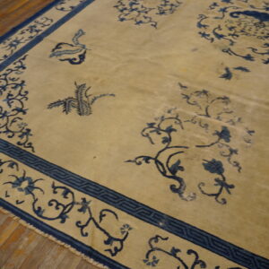 Beige rug featuring an all-over blue floral and geometric pattern on rustic wood flooring.