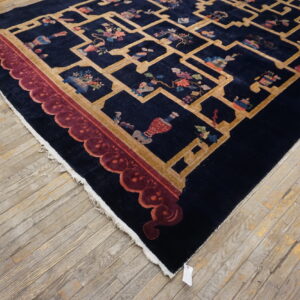 Navy rug with a gold trellis pattern, multicolored object motifs, and a maroon scalloped border on wood flooring.