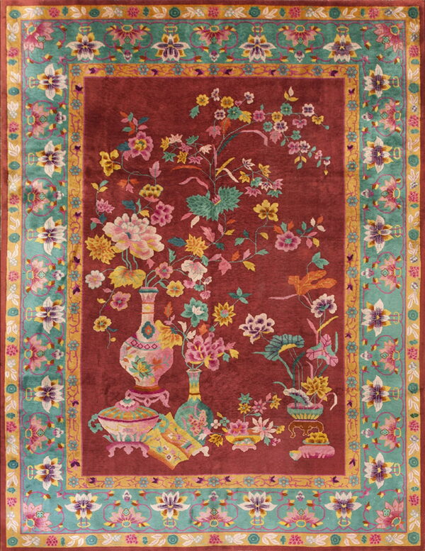 Red rug with an elaborate floral vase pattern and a complex turquoise and gold ornamental border.