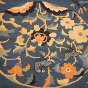 Ornate deep blue rug featuring a circular gold medallion with cream flowers, apricot accents, and stylized blue birds.