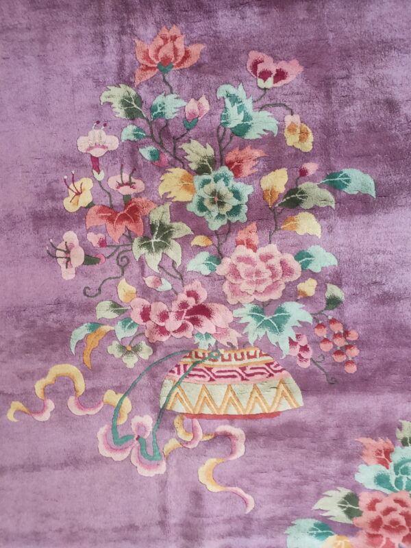 Plush purple rug featuring a large multicolored floral bouquet motif rising from a patterned vase.