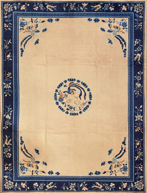 Beige rug featuring blue avian motifs and a wide navy border with a geometric key pattern.