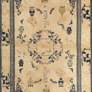 Light beige rug patterned with vases and a central floral wreath in blue and peach accents.