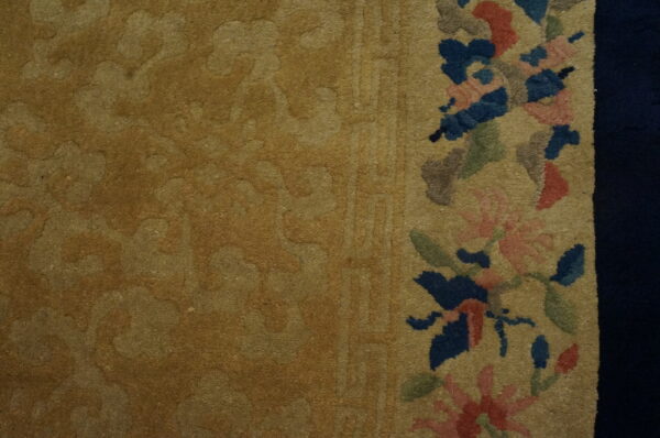 Gold carved rug texture with a colorful floral border featuring blue, pink, and green accents.