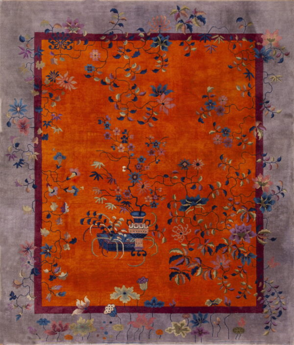 Orange rug with multicolor floral vines, an inner burgundy border, and a wide dusty gray outer border.