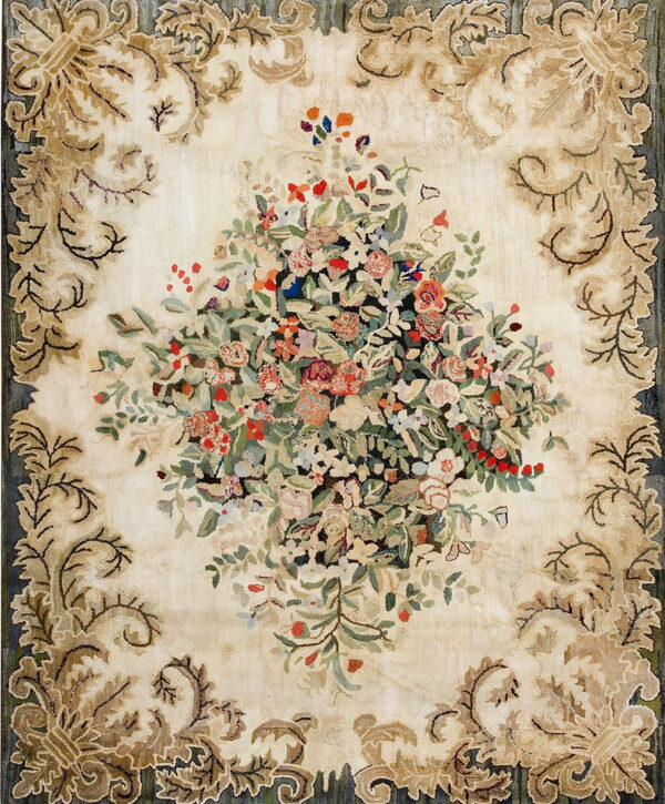 Ivory rug with a dense multicolored floral bouquet surrounded by tan scrolling acanthus leaf borders.