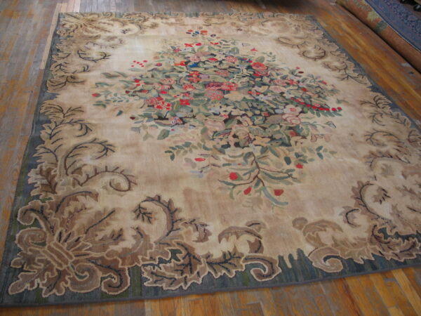 Beige rug featuring a vibrant floral center and a scrolling brown-and-green leaf border on wood flooring.