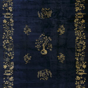 Navy blue rug featuring an intricate gold botanical border and scattered floral motifs in the center.