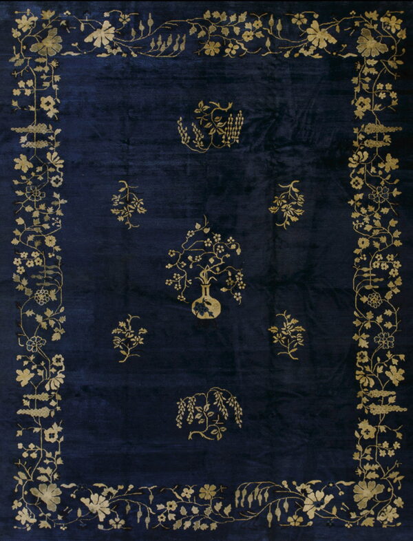 Navy blue rug featuring an intricate gold botanical border and scattered floral motifs in the center.