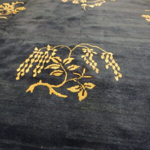 Navy blue plush rug featuring scattered golden botanical designs, including wisteria vines and blossoms.