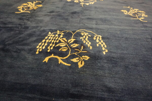 Navy blue plush rug featuring scattered golden botanical designs, including wisteria vines and blossoms.