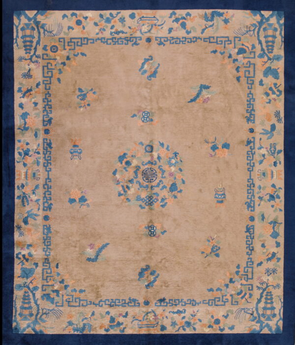 Tan rug with a navy border featuring blue, peach, and green asian floral and geometric designs.