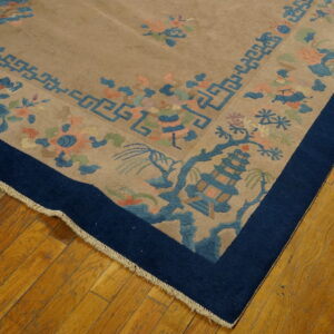 A beige rug corner displays blue pagoda, geometric fretwork, and soft floral patterns on hardwood flooring.
