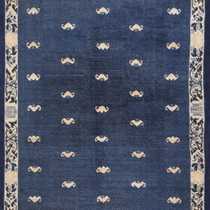 Low-pile rug with a blue geometric field, scattered beige stylized figures, and an ornamental cream border.