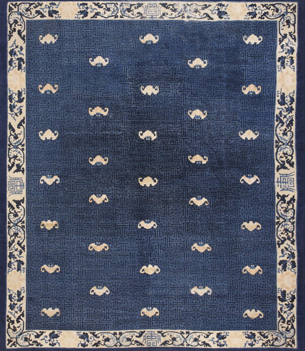 Low-pile rug with a blue geometric field, scattered beige stylized figures, and an ornamental cream border.