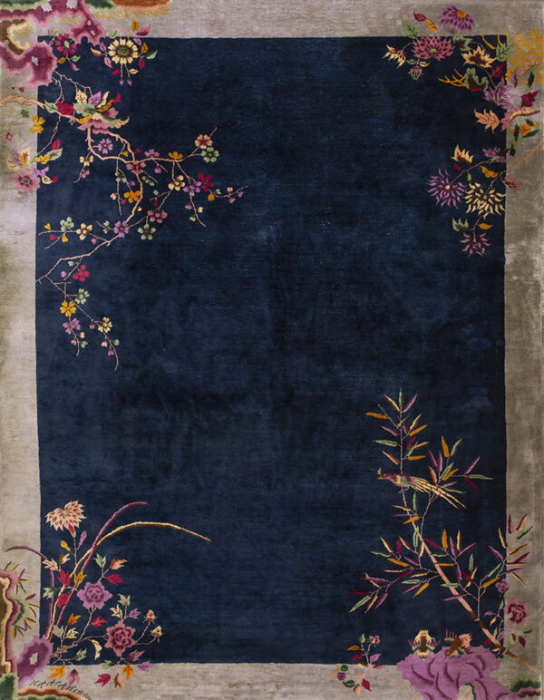 Plush dark blue rug bordered in muted gray, accented with multicolored flowers and branches.