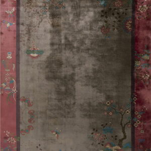Oriental rug with a faded gray field and a wide pink border full of colorful floral patterns.