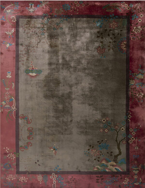 Oriental rug with a faded gray field and a wide pink border full of colorful floral patterns.