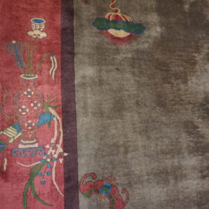 A red panel with a vase and floral pattern meets a wide, mottled grey field on wood flooring.