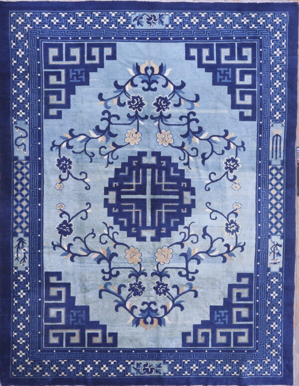 Blue rug with a pale field, dark blue geometric medallion, flowering vines, and detailed key pattern borders.