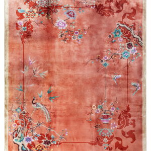 Variegated orange rug featuring an elaborate floral, branch, bird, and butterfly design in multiple colors.