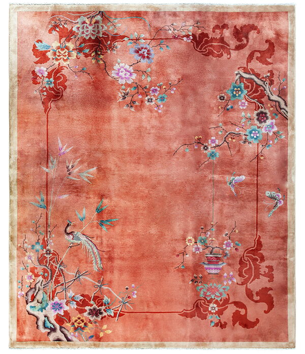 Variegated orange rug featuring an elaborate floral, branch, bird, and butterfly design in multiple colors.