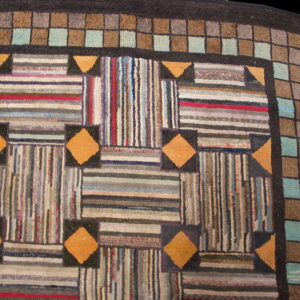 Multicolor striped patchwork rug with orange diamond accents and a repeating gray and teal checkered border.