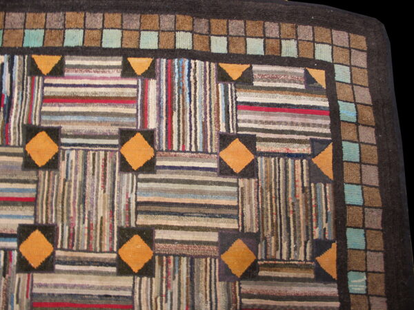 Multicolor striped patchwork rug with orange diamond accents and a repeating gray and teal checkered border.