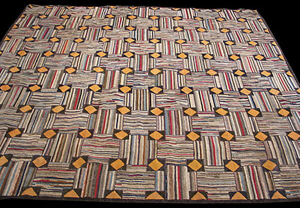 Textured rug with multicolored striped squares connected by golden yellow diamond motifs on a dark field.