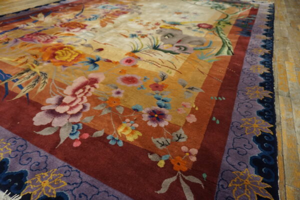 High-pile rug with colorful floral motifs, banded borders, and a purple cloud pattern on wood.
